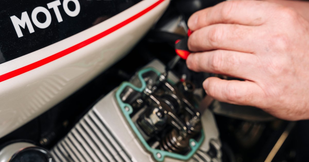 A close-up of a jet ski with the components exposed. Someone is working on the valves with a screwdriver.